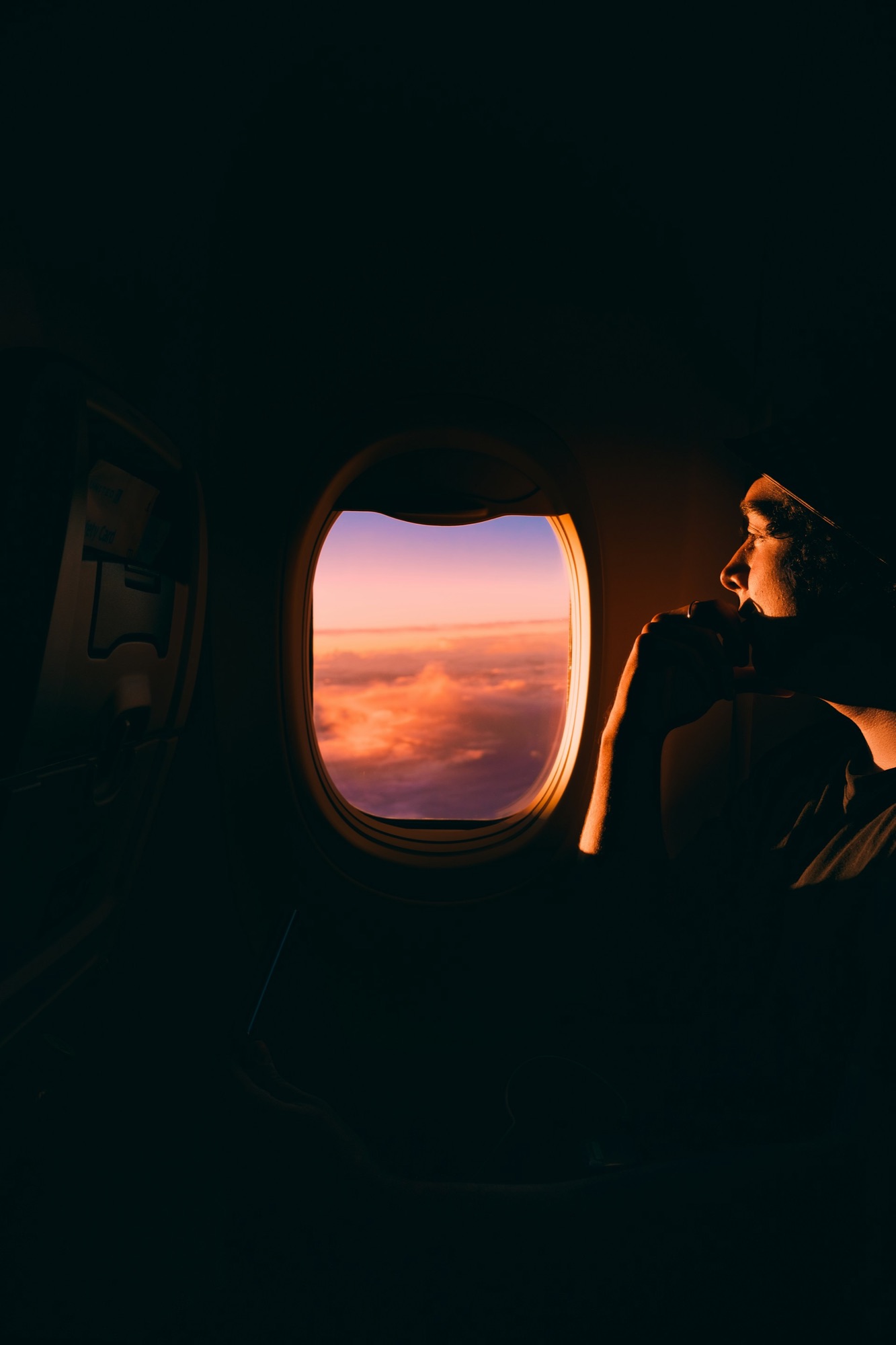Viaggiatore guarda il tramonto dal finestrino dell'aereo