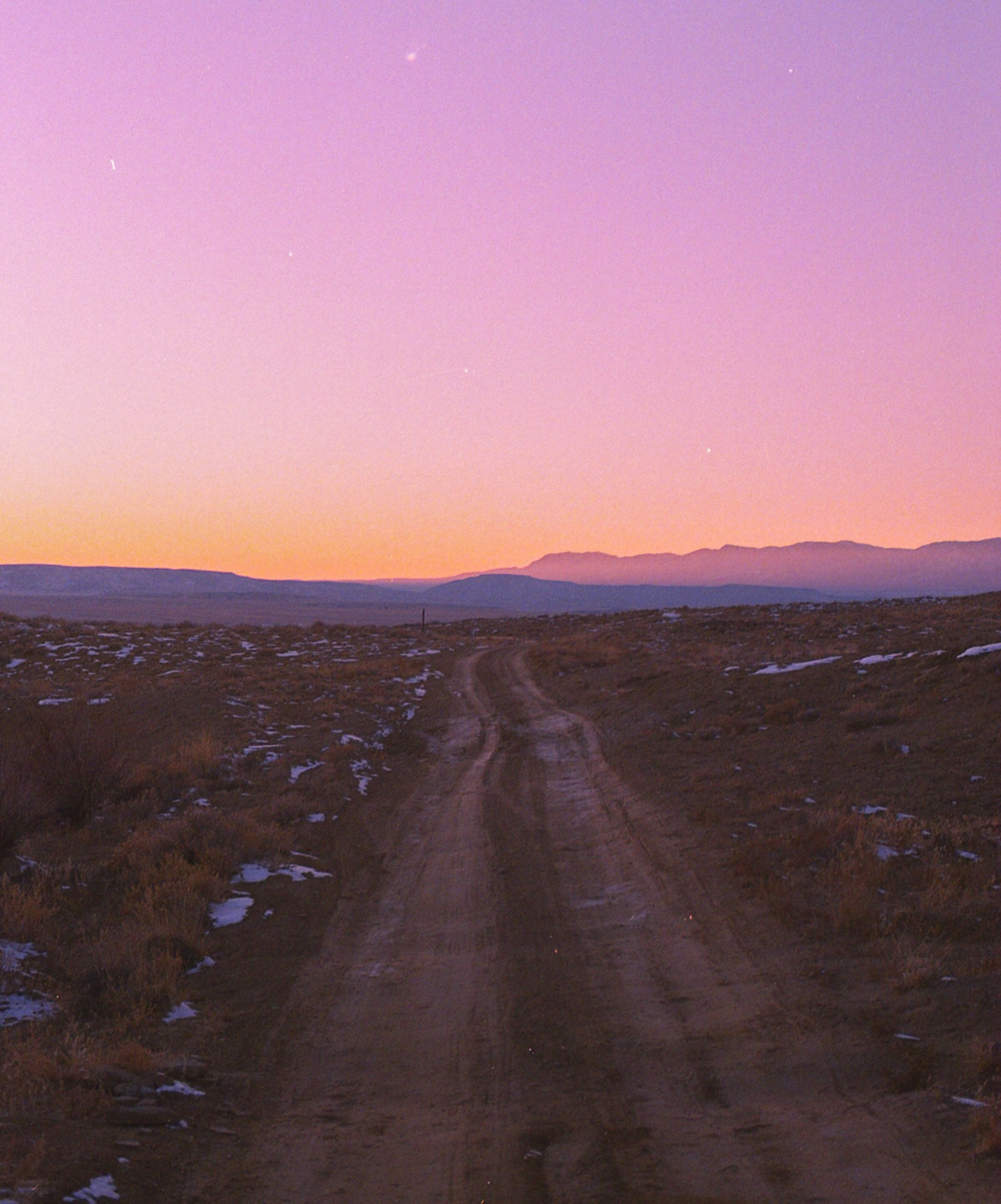 Strada sterrata verso le montagne al tramonto